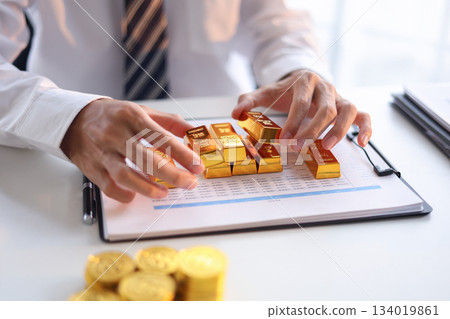 Businessman investing in gold to save assets against inflation and currency depreciation. 134019861