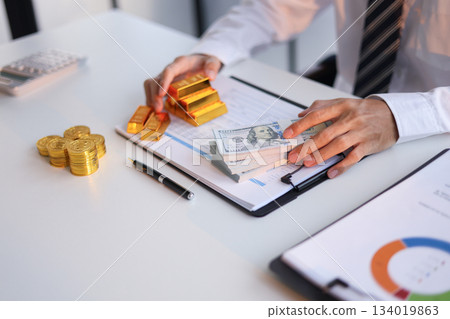 Businessman investing in gold to save assets against inflation and currency depreciation. 134019863
