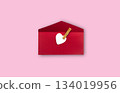 Red envelope with white card and red heart decoration, open, isolated on pink background, romantic and festive 134019956