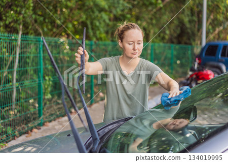 Woman cleaning her car, organizing seats and removing clutter to keep the vehicle tidy. Auto care, cleanliness and everyday routine concept, representing responsibility, order and modern lifestyle 134019995