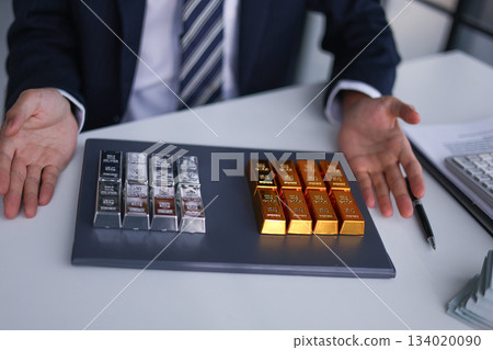 Businessman investing in precious metals gold and silver to diversify portfolios hedge against inflation and currency depreciation. Businessman investing in precious metals gold and silver to diversify portfolios hedge against inflation and currency depreciation. 134020090