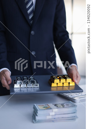 Businessman investing in precious metals gold and silver to diversify portfolios hedge against inflation and currency depreciation. Businessman investing in precious metals gold and silver to diversify portfolios hedge against inflation and currency depreciation. 134020092