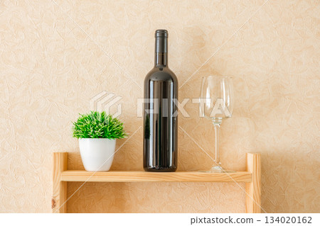 bottle of wine, glass and flower on shelf 134020162