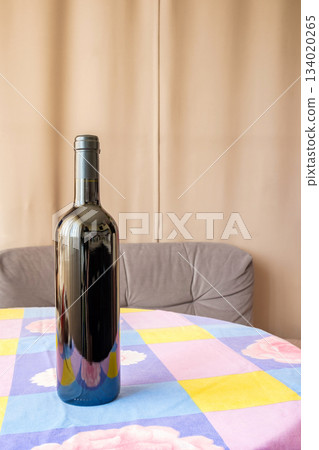 one bottle of wine on table with flowered tablecloth one bottle of wine on table with flowered tablecloth 134020265
