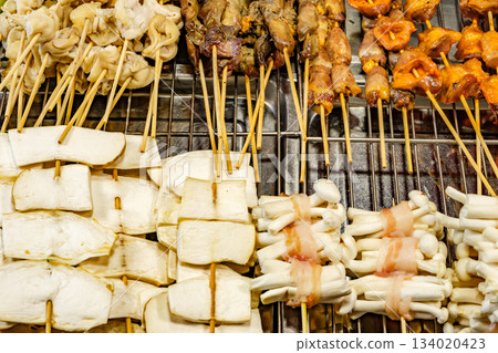 grilled seafood and vegetables on wooden skewers, street food, selective focus 134020423