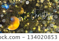 Golden Baubles And Christmas Lights On Tree With Merry Christmas And Happy New Year Text. Ideal For Christmas Festive Greetings, Winter Holiday Cards, Seasonal Marketing, Winter Celebration Campaigns  134020853