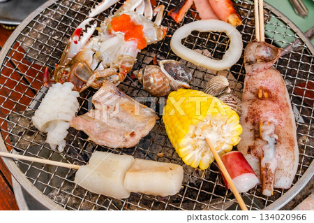 various seafood on wooden skewers are cooked on grill various seafood on wooden skewers are cooked on grill 134020966