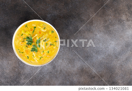 Traditional Indian mulligatawny soup with chicken, lentils, vegetables and herbs in a white bowl. Top view. Copy space. 134021081