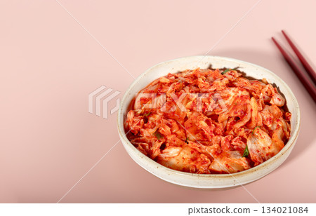 Spicy Korean fermented cabbage with chopsticks on pink background. Probiotic food concept. Copy space. Banner Spicy Korean fermented cabbage with chopsticks on pink background. Probiotic food concept. Copy space. Banner 134021084