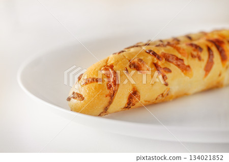 Baguette with baked cheese on white plate, selective focus 134021852