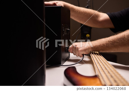 Home studio sound system adjustment, Decking speaker connections in recording space, Carefully connecting audio cables and calibrating sound levels in personal music studio 134022068