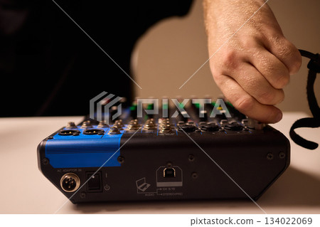 Closeup of tactile controls and vibrant patch cords in studio, Adjusting analog sequencing equipment with bright cables and warm ambient lighting in home studio 134022069