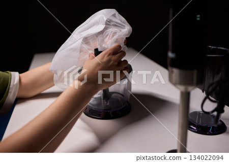 Preparing blender on kitchen counter, Scene shows detailed process of assembling immersion blender, Cozy kitchen scene of hands carefully putting together blending device 134022094
