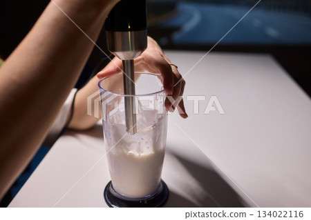 Creamy scoop presentation, Barista serving frosty ice cream, Frothy milkshake with chilled condensation display, Indulgent treat being carefully plated in minimalist setting 134022116