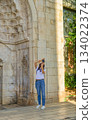 A girl tourist takes photographs of Hadrian's Gate, Antalya,Turkey 134022374