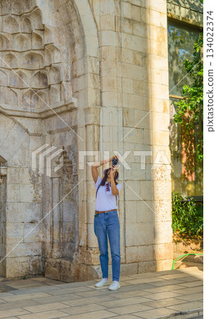 A girl tourist takes photographs of Hadrian's Gate, Antalya,Turkey 134022374