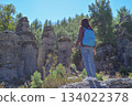 A woman tourist with a backpack on her back walks through the ancient city of Selga, admiring the wonderful nature and wonderful rocks. Turkey, Antalya. 134022378