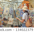 A young female tourist shops at a tourist market in Turkey looking for a bag or souvenir 134022379