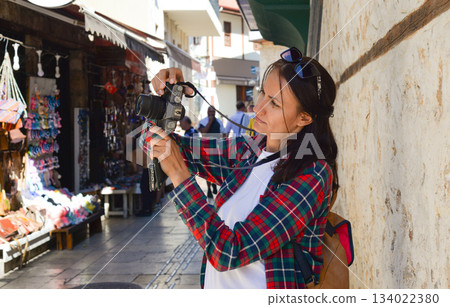 A young female tourist takes photographs of souvenirs at the tourist market in old Antalya, Turkey. A young female tourist takes photographs of souvenirs at the tourist market in old Antalya, Turkey. 134022380