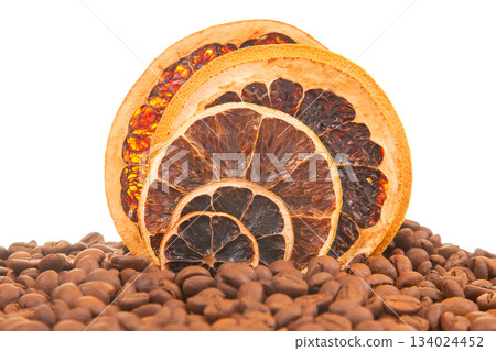 Detailed shot of dried citrus slices with vibrant hues, surrounded by aromatic coffee beans 134024452