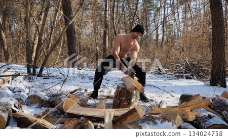 Shirtless strong man chopping firewood in a sunny winter forest. Muscular guy working with axe in snowy woodland. Concept of strength, masculine, energy and harmony with nature during cold season Shirtless strong man chopping firewood in a sunny winter forest. Muscular guy working with axe in snowy woodland. Concept of strength, masculine, energy and harmony with nature during cold season 134024758