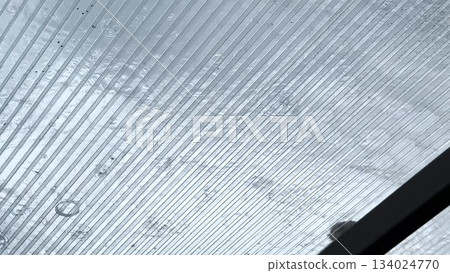 Heavy rain drumming on the transparent plexiglass roof. Beautiful rainy scene on summer day. Concept of tranquility nature scene. Close up Slow motion 134024770