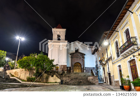 San Blas Church stands near the historic center of Quito, Ecuador. Colonial white Catholic church features stone entrance and bell tower illuminated under night sky San Blas Church stands near the historic center of Quito, Ecuador. Colonial white Catholic church features stone entrance and bell tower illuminated under night sky 134025550