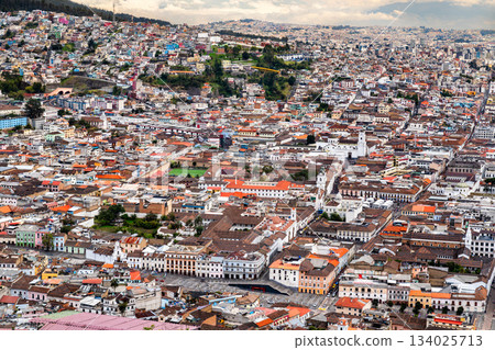 Historic center of Quito spreads out below El Panecillo hill in Ecuador. Panoramic cityscape features colonial churches and red tile roofs in UNESCO World Heritage site Historic center of Quito spreads out below El Panecillo hill in Ecuador. Panoramic cityscape features colonial churches and red tile roofs in UNESCO World Heritage site 134025713