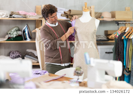Man tailor adjusts clothes on mannequin 134026172