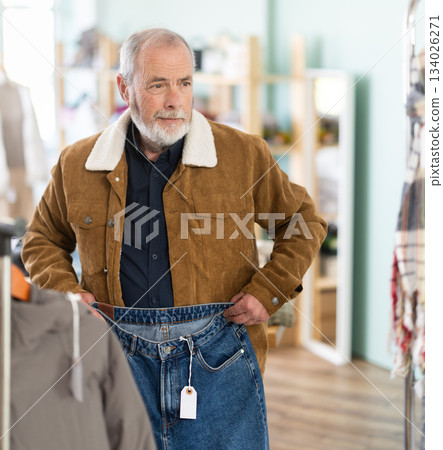 Mature man choosing jeans in a clothing store 134026271
