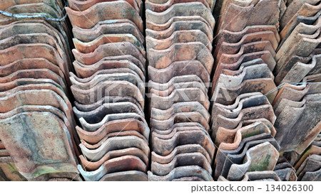 Intricate Pattern of Stacked Weathered Corrugated Terracotta Roof Tiles Intricate Pattern of Stacked Weathered Corrugated Terracotta Roof Tiles 134026300