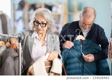 Family clothing store, senior couple customer chooses jacket or coat Family clothing store, senior couple customer chooses jacket or coat 134026463