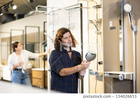 Handsome man choosing a shower head in hardware store 134026653