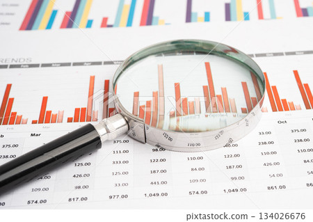 Magnifying glass on data business graphs paper. Magnifying glass on data business graphs paper. 134026676