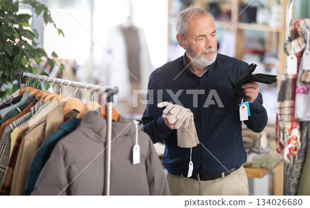 Mature man chooses stylish gloves 134026680