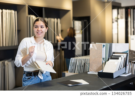 in hardware store,woman chooses ceramic tile with modern pattern for bathroom in hardware store,woman chooses ceramic tile with modern pattern for bathroom 134026785