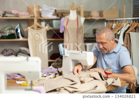 Mature man tailor sewing in workshop 134026821