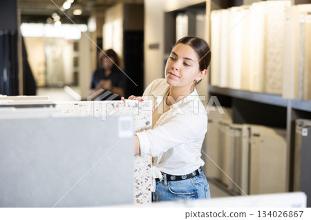 woman is considering MDF boards for internal insulation of residential premises woman is considering MDF boards for internal insulation of residential premises 134026867