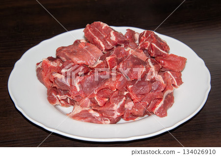 Piece of raw beef on a wooden cutting board. Piece of raw beef on a wooden cutting board. 134026910