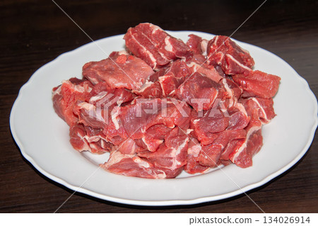 Piece of raw beef on a wooden cutting board. 134026914