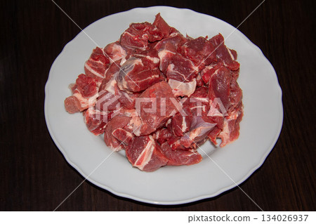 Piece of raw beef on a wooden cutting board. 134026937