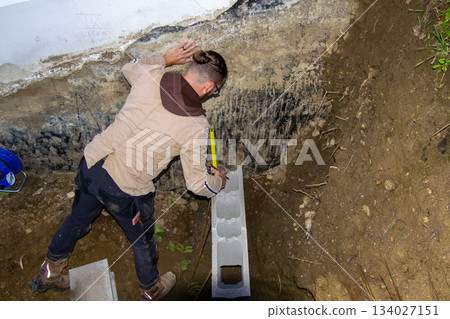Building a fundamental brick wall in a mountain. 134027151