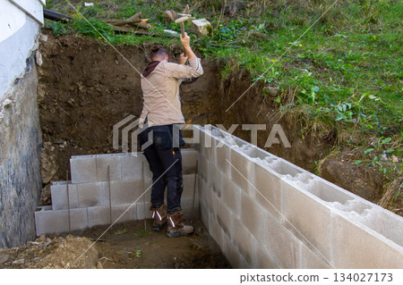 Building a fundamental brick wall in a mountain. 134027173