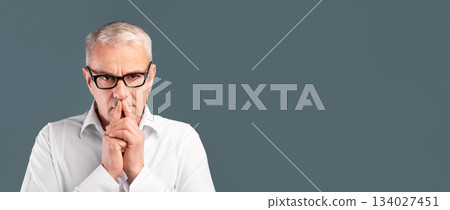 Let Me Think. Portrait of pensive senior man in glasses looking at camera isolated over blue studio wall, free space Let Me Think. Portrait of pensive senior man in glasses looking at camera isolated over blue studio wall, free space 134027451