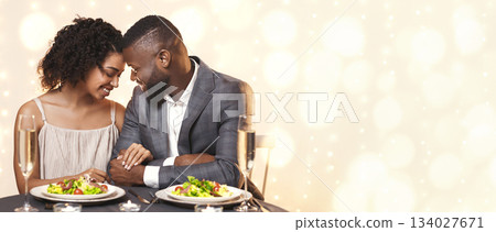 African couple in love bonding while having dinner at restaurant, love and relationships concept African couple in love bonding while having dinner at restaurant, love and relationships concept 134027671