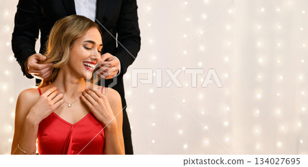 Luxury Gift. Loving Man Putting Golden Necklace On His Girlfriend's Neck At Date In Restaurant, Crop Luxury Gift. Loving Man Putting Golden Necklace On His Girlfriend's Neck At Date In Restaurant, Crop 134027695