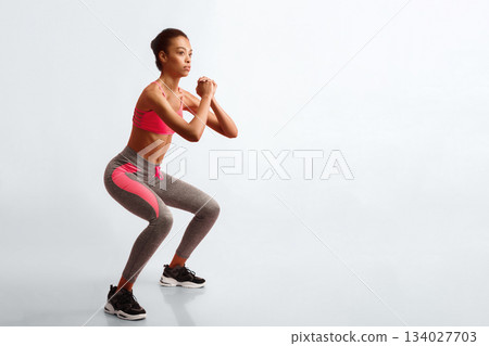 Fitness And Sport. African American Woman Doing Deep Squat Exercising On Pink Studio Background. 134027703