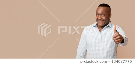 Life is good. Happy mature african american man gesturing thumb up on camera, orange studio background Life is good. Happy mature african american man gesturing thumb up on camera, orange studio background 134027770
