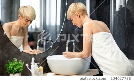 Woman Washing Face With Cold Water Standing Wrapped In Towel In Bathroom At Home. Selective Focus 134027788
