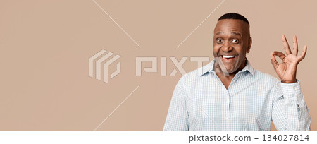 Everything is OK. Happy middle aged african american man gesturing okay sign and smiling, orange studio background Everything is OK. Happy middle aged african american man gesturing okay sign and smiling, orange studio background 134027814